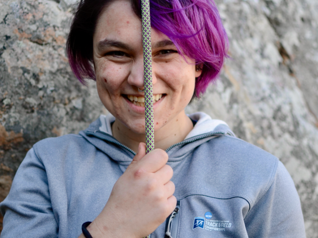 Kaitlin Sparks smiling with a climbing rope in hand